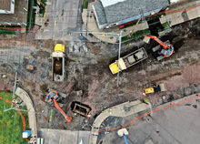 One excavator, at right, picks up section of concrete from the sidewalk and loads them into a dump truck as a second excavator works with a crew doing drainage replacement in the center of the intersection of East Seventh Street, top and bottom, and Poplar/East streets, left and right, in Bloomsburg Tuesday afternoon. 