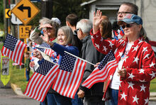 People along Main Street in Shickshinny wave hands and flags as the Memorial Day parade passes Monday morning.