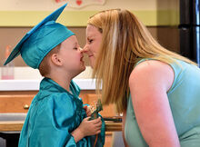 Nolan Cohick, 4, gives his mother Devin Cohick an Eskimo kiss while the pair sit and talk while waiting for the Danville Child Development Center’s preschool graduation ceremony Wednesday evening at its facility along Bloom Road. 