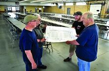 Members of the Columbia-Montour Council, BSA, historical committee, from left, Dale Neiderhiser, Marlin Hummel, Adam Folk and Charlie Gregory look over the floor plan as they set up the Industrial Building on the Bloomsburg Fairgrounds for today’s 100th anniversary celebration of the council. 