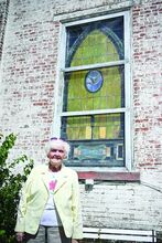 Gail Smith, the owner of Bloomingail’s, stands in front of one of the stained glass windows from her store, which used to be a church. She is donating them to the Berwick Historical Society after the building wasdestroyed by a storm outside of Berwick.