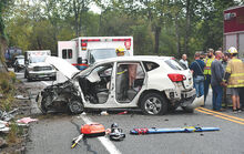 Firefighters and rescue personnel stand back after removing the driver from this Nissan Rogue following a collision with a garbage truck along Route 42 in Montour Township on Tuesday afternoon. 