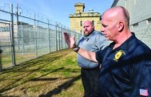 Columbia County Prison Warden George Nye, right, stands with captain Brad Hipps in a secure area of the prison Wednesday while talking about the new area of fences. The area has been constructed to use in case the prison needs to be evacuated in an emergency.