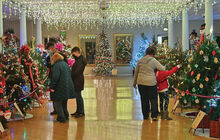 Visitors to the 33rd TreeFest walk among some of the 84 decorated trees on display at the Caldwell Consistory in Bloomsburg Monday afternoon after it opened to the public. 