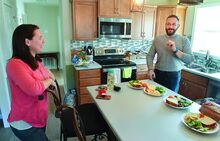 Kari Woodland, left, and her husband Josh Woodland stand in the kitchen of their new home Monday while talking about the help they received from their community and church to build the home after their builder closed.