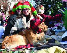 Press Enterprise/Jimmy May Buster sits next to Suzanne Hontz while riding on the Each One Teach One, day care and learning center float in the Berwick Santa parade Friday morning. 