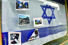 Press Enterprise/Jimmy May An Israel flag hangs in a Danville window along Mill Street Wednesday and someone has taped pro-Palestinian pictures on the outside of the window. 