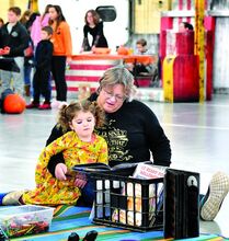 Deana Midway, Berwick, reads a book to her granddaughter, Haezel Spudes-Norris, 3, also of Berwick, at the Columbia County Traveling Library booth during the Columbia County 4-H Carnival on Saturday. 