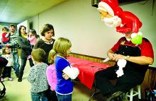 Wearing a balloon Santa on his head, Lanny Lee, Buckhorn, twists balloons into a polar bear for Morgan Marks, 8, of Catawissa during a Santa party for children age 10 and under, at the Catawissa Hose Company on Saturday.