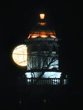 The full moon rises behind the dome on BU's Carver Hall 