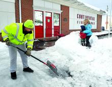 Continental Fire Company volunteer Michael Siats works to remove ice from the fire hall parking area