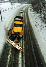 A PennDOT plow truck clears snow from Lightstreet Road while heading into Bloomsburg