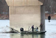 Dave Carey and Matt Williams prepare to hook up a downed tree limb that has formed a blockage near a pier on the Catawissa Bridge Wednesday afternoon. The Rylind Company of Mount Wolf is puling debris from 14 bridges throughout the area of the next several weeks. The crew will be working on the East Bloomsburg Bridge today according to Marshall Sweigard, project manager.