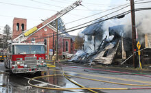 Water from the Nanticoke Ladder truck pours down on the burned out middle of this home at the intersection of Grant Street and Route 11 in Shickshinny Friday afternoon.