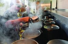 Press Enterprise/Jimmy May Daniel Williams, left, and Dan Nicolella work together while cooking pierogies in pots of boiling water cover the stove at Ss. Cyril & Methodius Ukrainian Catholic Church in Berwick Thursday. 