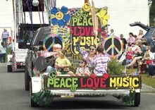 Members of the Breskiewicz family, above, ride on their Peace Love Music float in the All Home Days Parade as they arrive at Ralpho Township Community Park. Activities will continue in the park today and Monday.