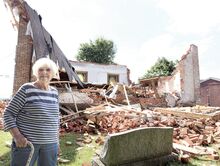 Gail Smith, owner of Bloomingail’s Gift Shop along Martzville Road, poses in front of what remains of it Friday.