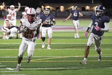 Bloomsburg's Jharee Moore-Stewart carries the ball into the end zone ahead of Shikellamy’s Owen Elliott during Friday night’s game at Shikellamy.