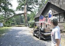 Alex Bohm, a staff member at Camp Lavigne, describes the damage to the Great Oak, a staple of the camp, after a storm came through Monday night.