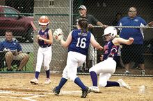 Danville baserunner Alivia Bergey slides safely into home as Warrior Run pitcher Brooke Bryson waits for the throw following a passed ball in the second inning of the District 13 elimination game at Central Columbia on Sunday. Danville’s batter stepping out of the box is Madison Patterson. Watching the play from Warrior Run’s dugout are assistant coach David McCarty, left, and manager Keith Bryson. Danville won 8-5.