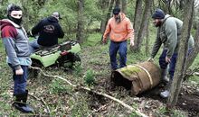 Fishing Creek cleanup volunteers, top photo, use a four- wheeler to pull a rusted 55-gallon drum away from the bank on Sunday afternoon. From left are Mason Weaver, 9, Catawissa; Mason’s dad, Justin Weaver, on his four-wheeler; Thomas Person, Bloomsburg; and Jared Mench, Catawissa. The drum was filled with a substance the men theorized was hardened burn-barrel ash.