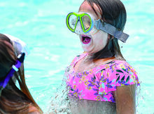 ava Derr, 6, pops up from under the water with her friend, Layla Gavitt, at the Little Fishing Creek Area Swimming Pool in Millville Monday afternoon. The community pool is open seven days a week until 7 p.m.