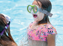 Ava Derr, 6, pops up from under the water with her friend, Layla Gavitt, at the Little Fishing Creek Area Swimming Pool in Millville Monday afternoon. The community pool is open seven days a week until 7 p.m.