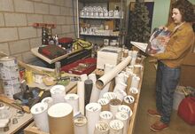 Patrick Foust is shown Wednesday flipping through tile samples next to blueprints from former Columbia Mall stores. The mall's owner is selling off its contents.