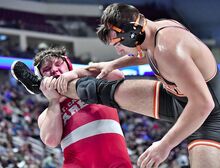 Mount Carmel's Damon Backes lifts the leg of Hayden Linkerof of Corry Area during the PIAA Class 2A Wrestling Championships at the Giant Center in Hershey on Friday.