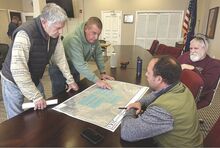 Pickleball players Wayne Badrigan, left, and Brian Wawroski look over plans with Town Engineer Drew Barton and Councilman Jim Garman after a pickleball information meeting Thursday. The town planned to build at least four pickleball courts at Streater Field this summer. But Barton said players’ enthusiasm prompted him to draw up a larger, more costly plan