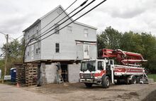 A crew works on raising the home at 334 E. Ninth St. in Bloomsburg out of the flood zone on Monday afternoon.