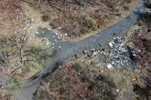 Trash that’s been illegally dumped is strewn along a path off the blacktop in Byrnesville, Conyngham Township.