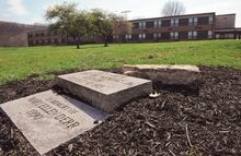 Three memorial markers sit on a pile of mulch along the Railroad Street side of Bloomsburg High School Thursday afternoon. They were removed from their original location due to floodwall construction around the school.