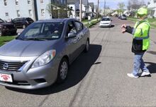 Nescopeck Fire Chief Captain Bill Smith directs traffic for the food distribution in Nescopeck Tuesday morning. Recent complaints about blocked intersections and driveways led to warnings from the borough police, which visitors heeded.