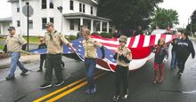 Members of Scouts BSA Troop and Pack 51 carry the large flag down Main Street during the Benton VFW Memorial Day parade in Benton Sunday afternoon. The parade moved down Main Street, across the Fishing Creek bridge and up the hill to the cemetery.