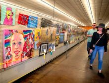 Visitors look over the paintings displayed in Arts and Crafts Hall at the Bloomsburg Fair.