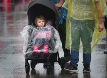 Kiera Crist, Gordon, is pushed around the fairgrounds by her parents during a heavy downpour Tuesday afternoon.