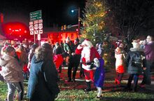 Santa Claus mingles with the crowd in front of the Bloomsburg Diner after his arrival by fire truck to downtown Bloomsburg on Friday evening.