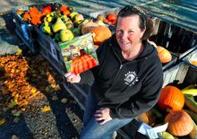 Denise Bosworth, owner of Rohrbach’s Farm Market, holds her children’s book, “Penelope Pumpkin”, outside the farm market recently.