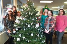 Bloomsburg Medicine Shoppe employees pose with a decorated tree Wednesday morning at the Market Street pharmacy. The tree is adorned with empty vials of the COVID-19 vaccine, vaccination cards and lights. From left are Brianna Boyer, Jennifer Seltzer, Cindy Cymbala, Karen Houseknecht, Angie Butrej, Gillian Schlichter and Jessica Parker.