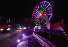 Visitors to “Joy Through the Grove — A Christmas Light Experience” head off through Knoebels Amusement Resort as they pass the light show on the giant Ferris Wheel. This the second year the park has hosted a holiday light display.