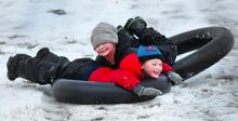 Brenden Hauck, bottom, and brother Brantley of Lime Ridge crash into each other as they snow-tube down the hill at Columbia Park in South Centre Township Monday afternoon.