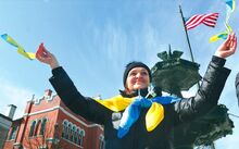 Nataliya Petryshak waves Ukrainian flags as the American flag hangs above her Sunday during a Rally to Support Ukraine at the fountain in Bloomsburg. Petryshak lives in Berwick with husband Roman, pastor of Ss. Cyril & Methodius Ukrainian Catholic Church. The couple is from Ukraine.