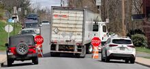 A tractor trailer turns from East Fourth Street onto Spruce Street in Bloomsburg on Monday afternoon while moving between temporary stop signs after the existing stop sign had been run down earlier in the day. Town Police have fielded more than 20 traffic calls since the construction detour began.