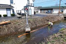 Pennsylvania Fish and Boat Commission Employee Owen Welch maneuvers a log into the bank of Kinney Run in Bloomsburg on Tuesday morning. The crew placed single logs as diffusers to help with water flow in the stream.