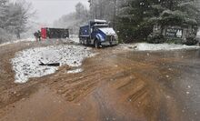 The blue dump truck, foreground, was spun around after being rear-ended by the red dump truck, overturned in background. The blue truck had slowed down on Route 442 to make the right turn into the White Pines landfill in Pine Township Monday afternoon as snow started to fall.