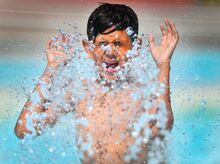 Jomar Batista, 12, Berwick, runs into a sprinkler Thursday morning at Ber-Vaughn Pool. Batista was with other Berwick YMCA campers.