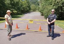 Joan McCarty, left, stands with Scott Township Police Officer Evan Lingousky at the entrance to Kocher Park near Lightstreet. The park was closed to the public Saturday morning and will remain so indefinitely, according to McCarty, one of its overseers.