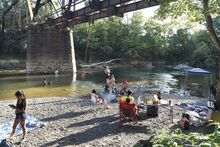 Folks gather to swim, picnic and try the rope swing at the railroad trestles over Fishing Creek in Bloomsburg Saturday.