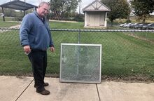 Danville Area acting Superintendent Harry Mathias points to a classroom window that authorities say was pierced by a bullet.